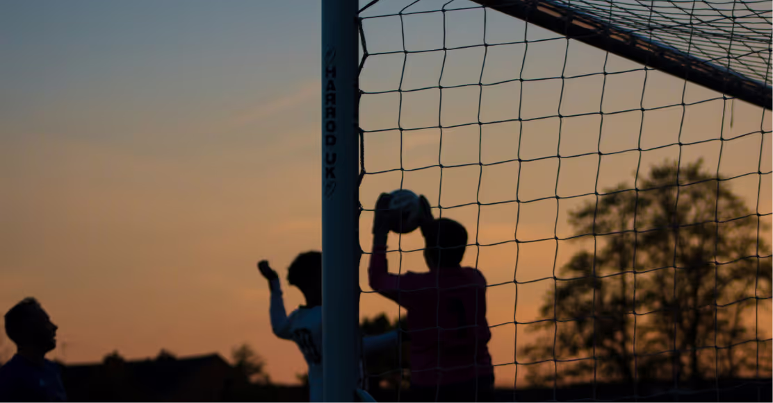A goalkeeper in front of a soccer goal